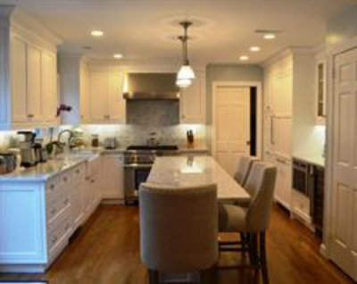 White kitchen with under-cabinet lighting and dining island