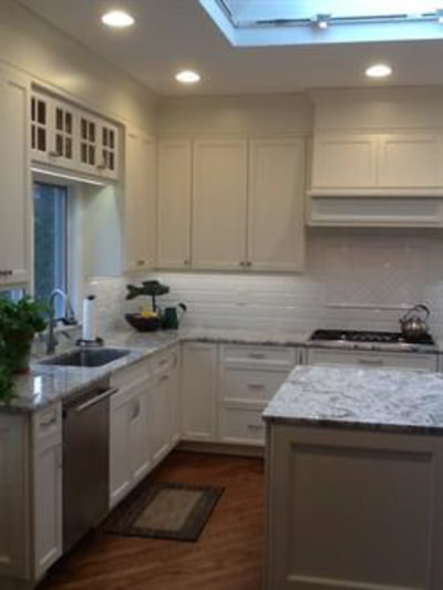 White kitchen with glass-door cabinets and marble-look countertops