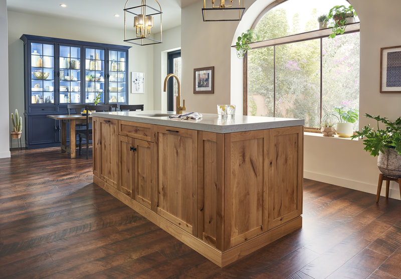 Natural wood kitchen cabinetry with glass display unit and work island