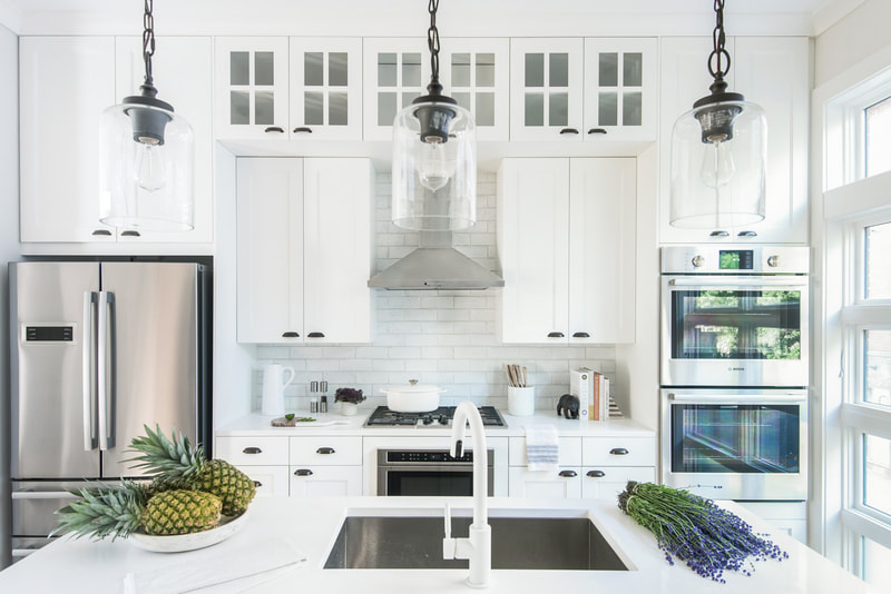 White kitchen with work island and stainless steel accents