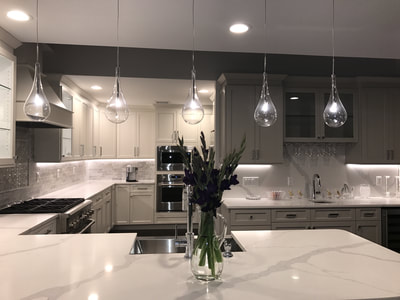 White kitchen with C-shaped countertops and decorative lighting