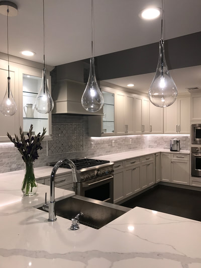 White kitchen with under-cabinet lighting and tiled backsplash