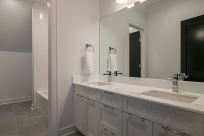 White bathroom remodeling project with double vanity and storage underneath
