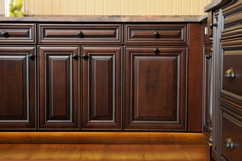 Dark wood color cabinetry with dark round knobs