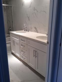 White master bath with double vanity and overhead lighting