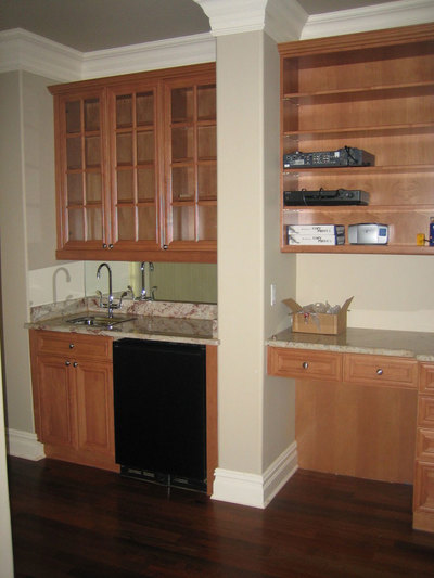 Wet bar with natural wood color glass-door cabinets