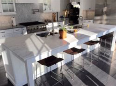 White kitchen with dining island and tiled backsplash