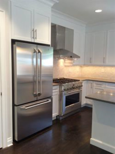 White kitchen with stainless steel appliances and under-cabinet lighting