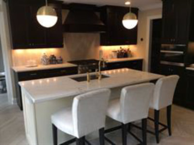 Black-and-white kitchen with under-cabinet lighting and dining island