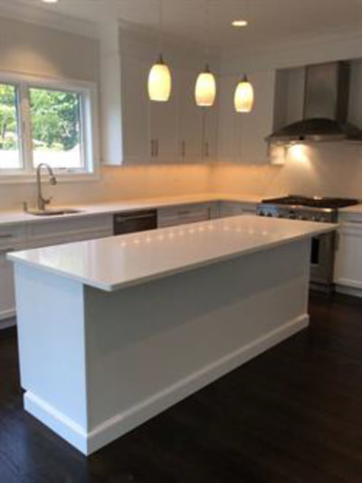 White kitchen with dining island and under-cabinet lighting