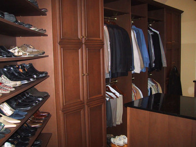 Custom walk-in closet with shoe shelving and hanging storage at multiple heights