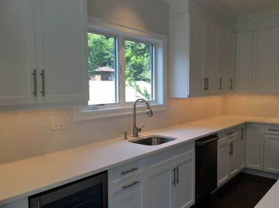 Kitchen remodeling project with white cabinetry and countertops