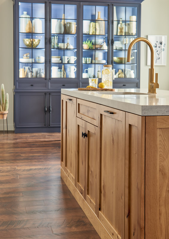 Natural wood and color kitchen cabinetry with work island and glass display unit